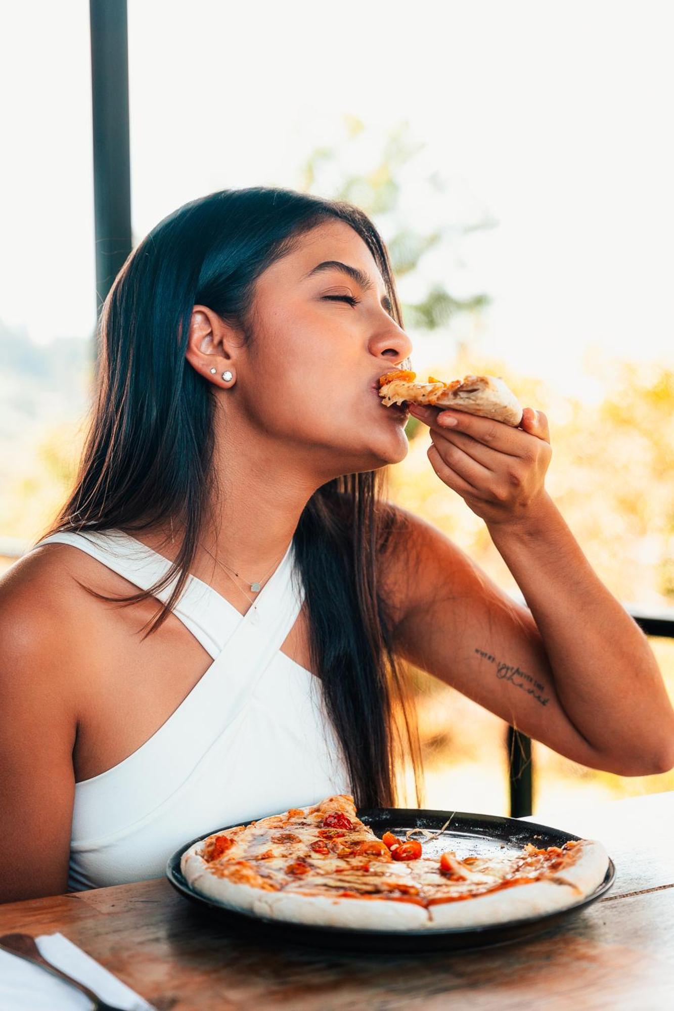 The Boato Hotel Guatape Ngoại thất bức ảnh A woman eating pizza